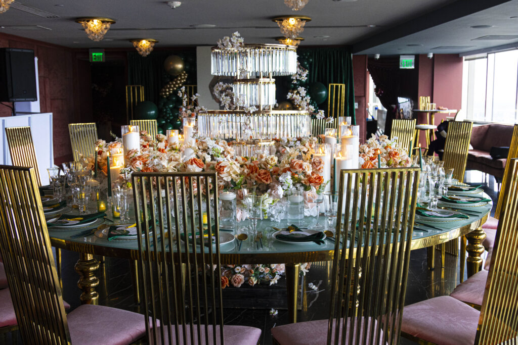 Luxury event table featuring tall gold chairs, mirrored tabletop, sculptural centerpiece, and premium furniture rentals by Events D’Lux