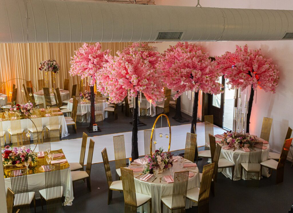 Vibrant cherry blossom tree centerpieces creating an Instagram-ready wedding reception moment.