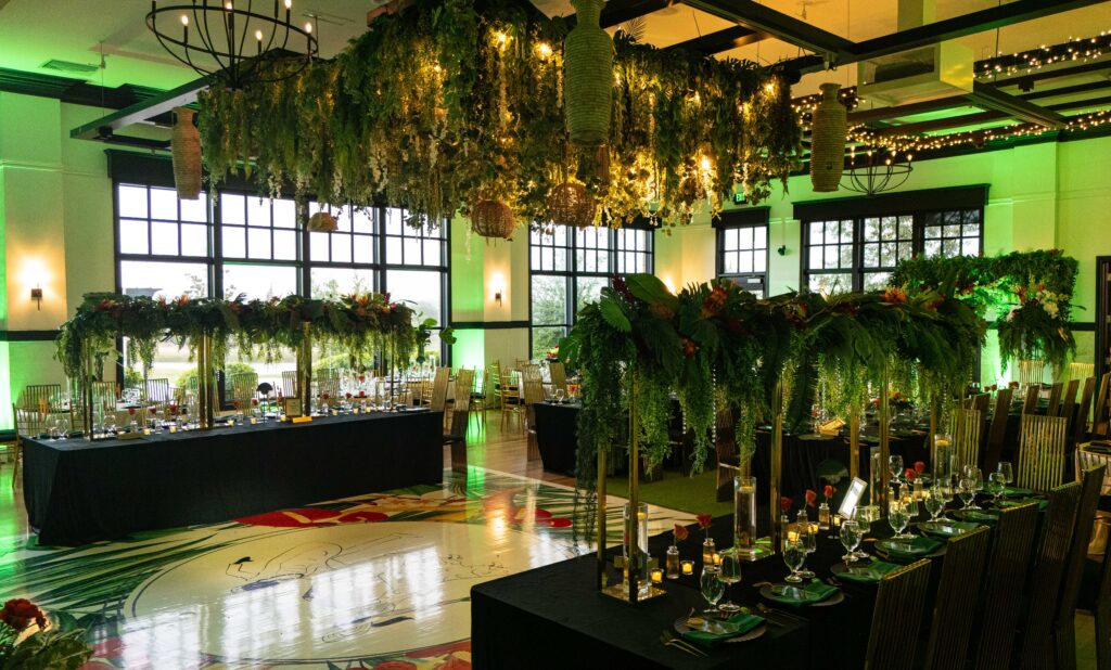 Hanging floral ceiling installation with lush greenery creating an immersive architectural canopy for a luxury dinner event