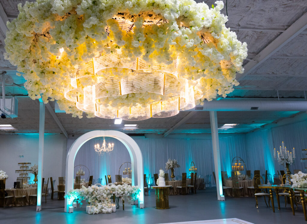 Immersive floral ceiling with chandeliers and sculptural lighting at a luxury event